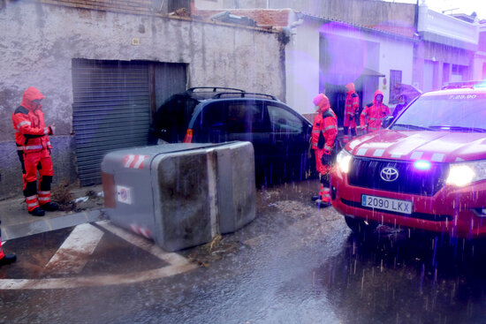 Firefighters examine damage caused by vehicle dragged by flooding (by Jordi Marsal)